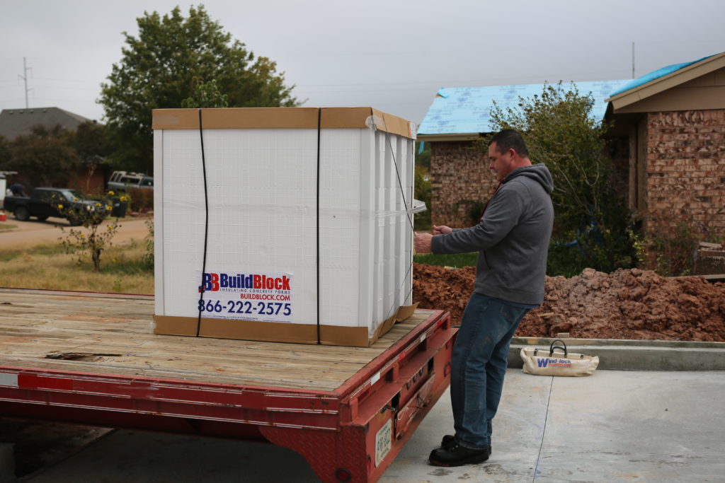 Team member unloading a bundle of BuildBlock forms from the truck