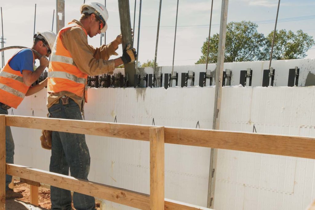 Crew pouring concrete while on top of walk-boards