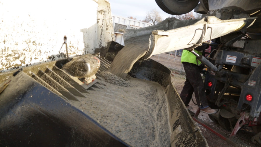 Concrete being poured from the truck into the Pump Truck Hopper