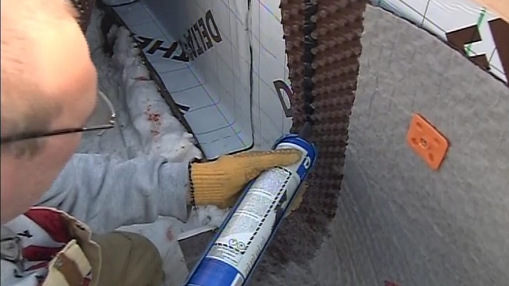 Applying mastic to a dimple drainage mat