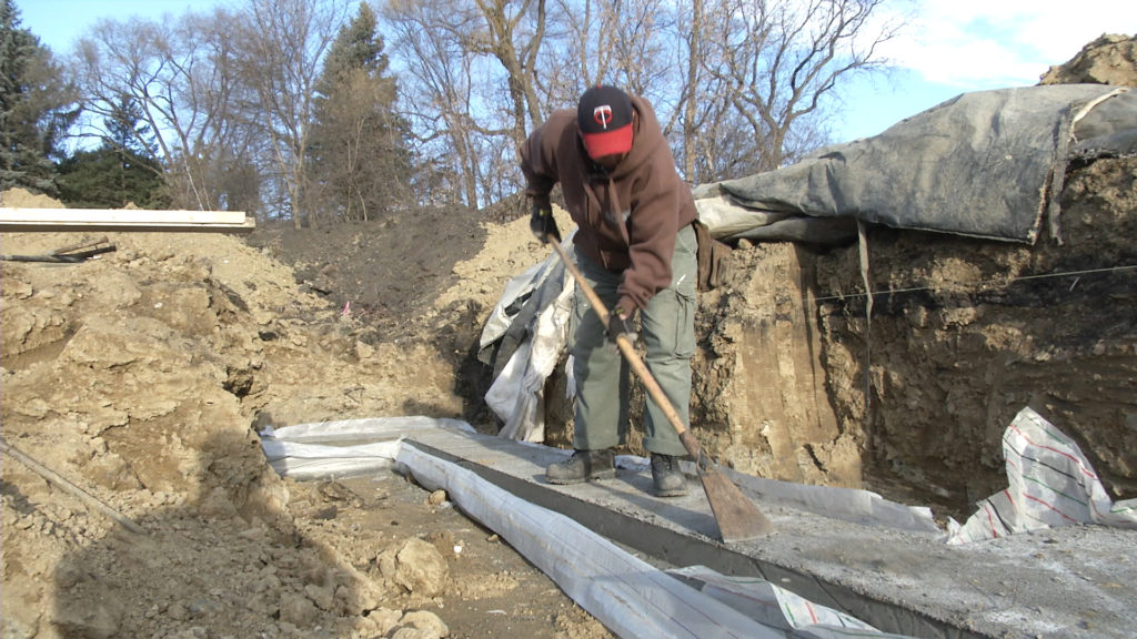 Team member scraping the footing clean before stacking blocks